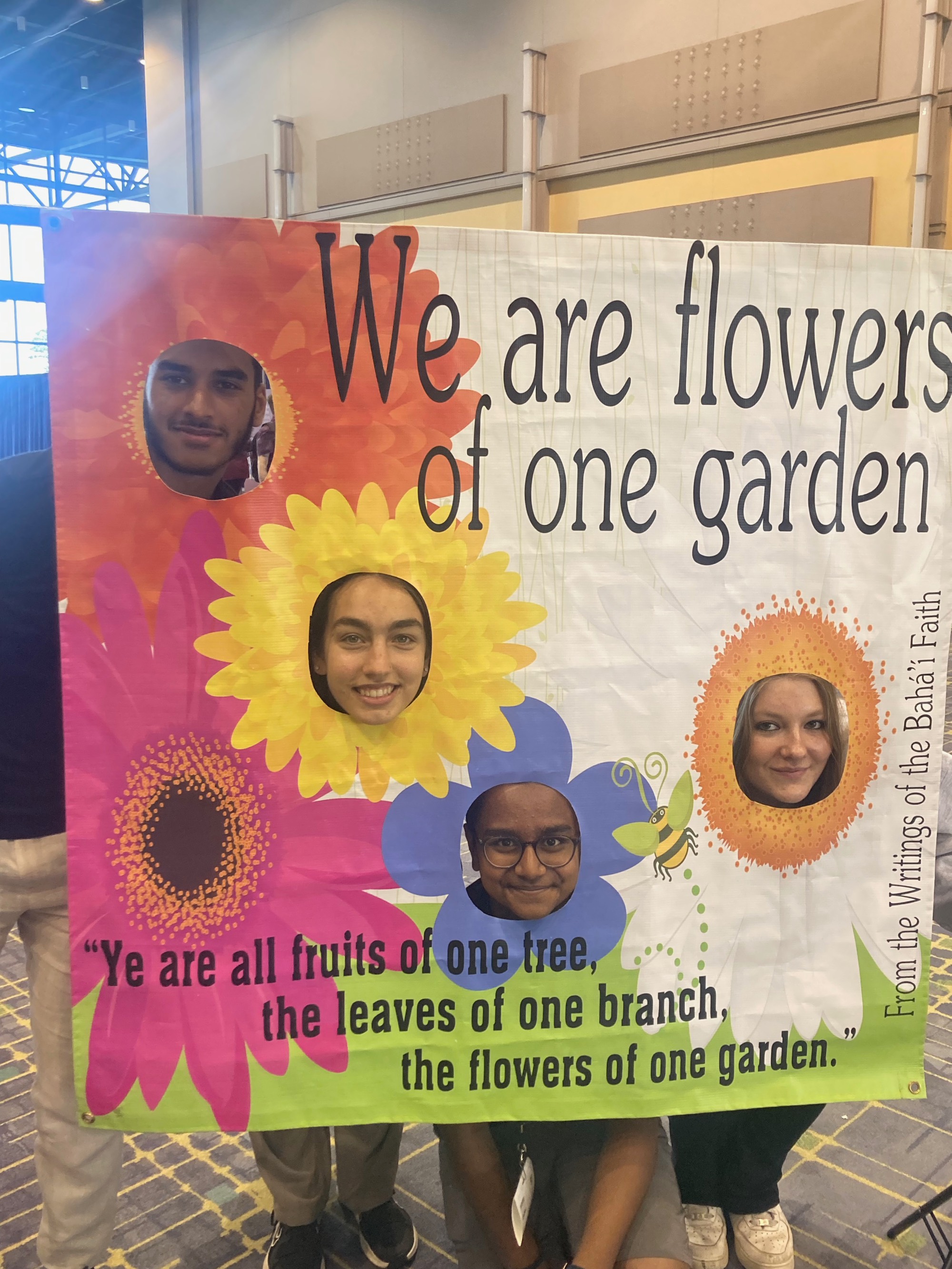 Four students in a photo frame with face cut outs